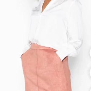 Persikofärgad kjol - Kort kjol i suede. Endast använd en gång då den är lite för stor. Kjolen är i storlek S men är lite stor i midjan så passar nog mer som storlek M. Köparen står för frakt!