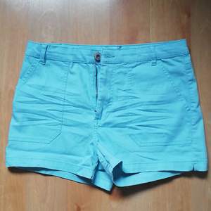 Ett par ljusblåa jeans-shorts som passar utmärkt till sommaren. De är använda 2 gånger och självklart tvättade. Har knapp, dragkedja och möjlighet till skärp, samt fickor bak och fram. 76% Bomull, 2% Elastan och 22% Polyester. Pris + inkl. frakt. 