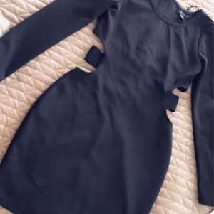 Festklänning från Amisu - En snygg klänning med skuren midja och banddetaljer.