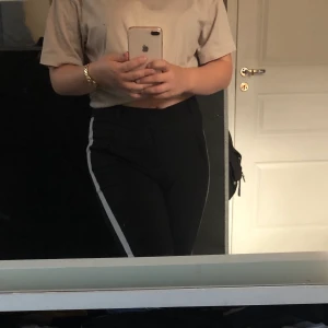 Svart kostymbyxa - Svart kostymbyxa från Vero Moda med vitt streck på benen. Stretchigt material och drar inte åt sig damm, hår etc. Byxorna är i en kortare modell och går över ankeln på mig som är 158cm. Priset kan diskuteras 🙂