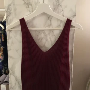  - Skön, vinröd långklänning. Kan användas både till vintern och våren då den är stickad men sval. Aldrig använd. 