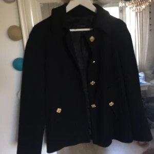  - Svart, lite tunnare kappa med guldfärgade detaljer från ZARA basic. 