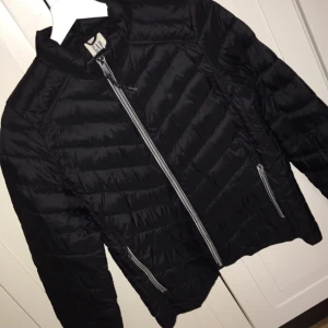  - Svart dunjacka ifrån GAP , knappt använd, köparen står för frakten