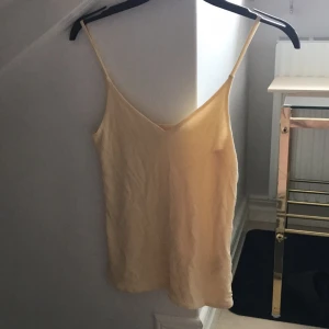  - Ljusgult linne med tunna band, svagt v-ringat tight modell från hm trend   Fint skick!!