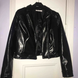  - Lackad skinnjacka från NAKD med rosa/rött och blått blom broderi på baksidan. Nypris 700k  storlek 38, använd ca 3 gånger 