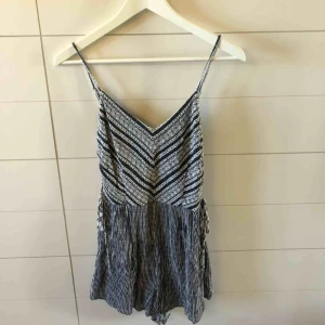  - Jättesnygg vit och mörkblå playsuit från Bershka i strlk S! Snörning på sidorna och justerbara axelband. Frakt 50kr eller möter upp i Kristinehamn 