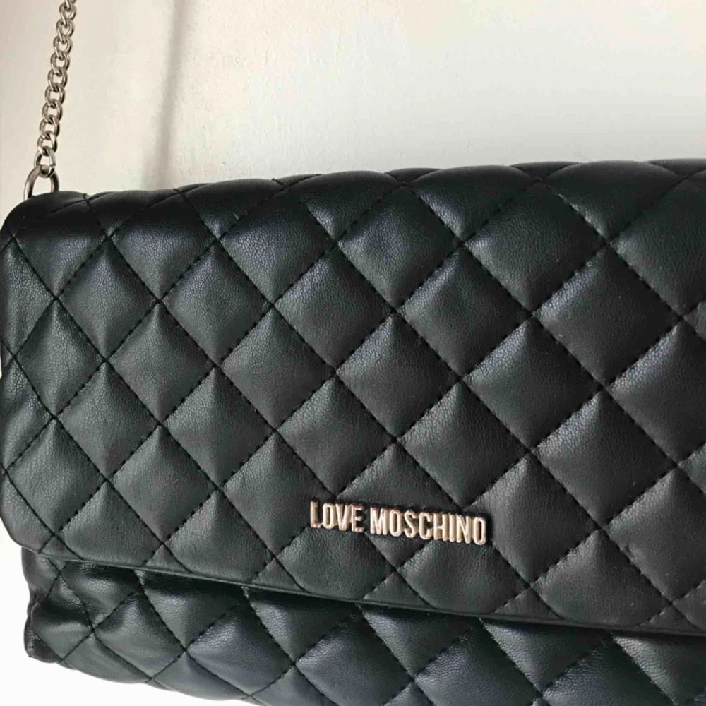 Äkta Love Moschino-väska, köptes för 2 år sedan. Väskan är i fint skick men har en liten slitning vid knäppet, inget som riktigt syns. Frakt ingår.. Väskor.