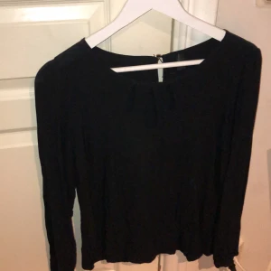 Svart blus med detaljer  - En Svart blus, Med ovala hål vid bröstet, knappt använd. Blusen är från vero Moda