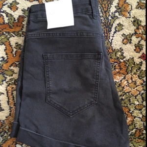  - Svarta jeansshorts med hög midja. Aldrig använda. OBS! Köparen står för ev frakt.