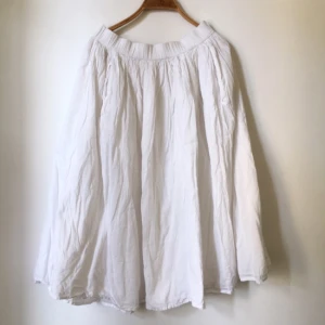  - En vadlång vit kjol i bomullstyg och fickor i sidorna! Bred resår i midjan och två lager tyg för att den inte ska bli genomskinlig och för att ge den mer volym i fallet! Fint skick! 