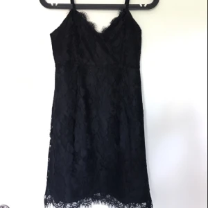  - Svart spetsklänning med dragkedja bak. Kort i storleken. Bra skick!