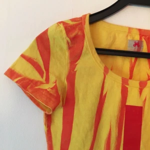  - Ball magtröja, typ eld-batik-mönstrad med rött streck fram. 90/2000-tals style. Ca XS-S i storlek. 60 kr inklusive frakt