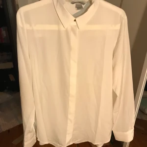Vit skjorta - Vit skjorta från hm i storlek 38 som kan stylas på många sätt. Endast använd 2 gånger så i nyskick. Går att knäppa alla knappar orkade bara ej göra det. Frakt tillkommer.