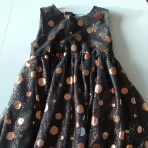 Name it festklänning i nyskick strl 110 champagne färgad - Riktigt riktigt söt, använd en gång. Svart grund och champagne färgad. En liten dröm!