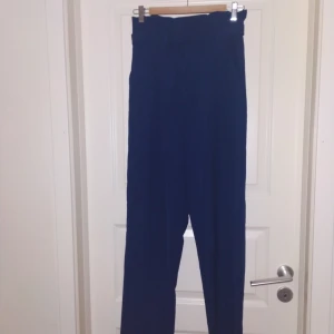  - Oanvänd paperbag byxor i mörk indigoblått. Från Bik bok