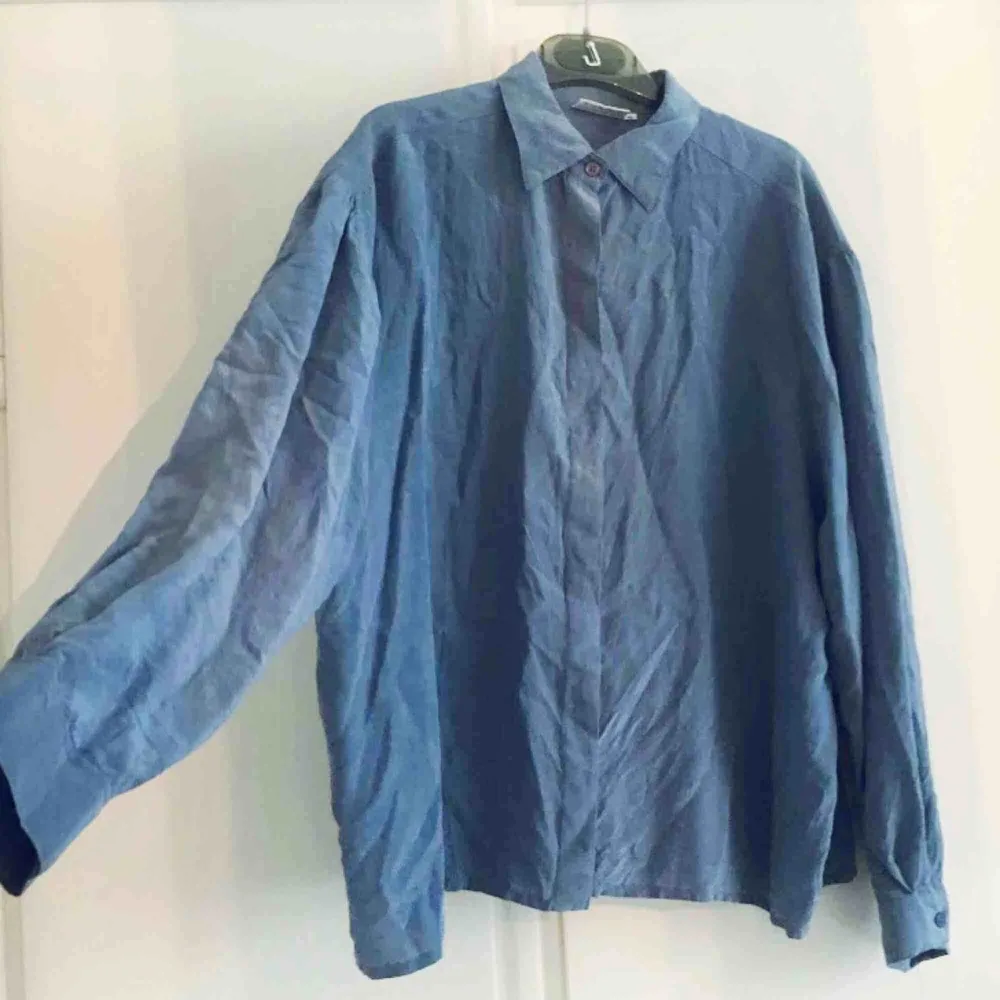 Dimblå blus köpt second hand. 100% silke. I bra skick. Märkt storlek 42, passar mej oversized som är en 36a.. Blusar.