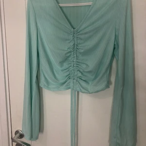 Marinblå top - Marinblå top med dragknytning i mitten, vida armar, ribbad, använd vid fåtal tillfälle 