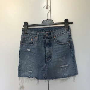 Levis jeanskjol strl 36 - Jeanskjol från Levis med slitningar. Originalpris 599kr.