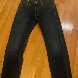 Blåa jeans från Levi's 502 - Snygga svarta jeans från Levi's med klassisk femficksdesign och knappgylf. Perfekta för en stilren look. Levi’s 502, sitter slim fit fast lite mer utvidgade skulle påstå slim fit straight jeans är de som 