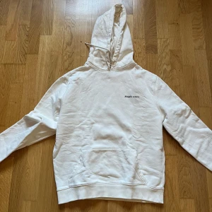Vit hoodie från Arigato - Säljer en stilren vit hoodie från Arigato med tryck både fram och bak. Skick 8/10, sitter S/M