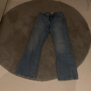 Blå bootcut jeans - Säljer ett par klassiska blå bootcut jeans. Perfekta för en avslappnad stil med en tidlös design. De har en bekväm passform och är gjorda i ett slitstarkt material.