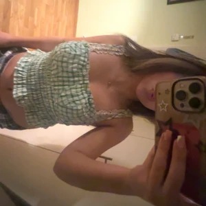 Grön och vit rutig linnetopp - Söt grön och vit rutig linnetopp med smala axelband. Toppen har en croppad passform och elastisk midja. Toppen är från Koton i Turkiet och har används 2 gånger, alltså är den i myxket bra skick. 