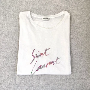 Saint Laurent tee - Saint Laurent t-shirt i storlek S, passar mer som M. Mycket bra skick bortsett från minimalistisk lagning, syns ej. Tröjan är självklart äkta😊