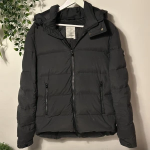 J.Lindeberg jacka - Tja säljer denna snygga svart/grå dunjacka från J.Lindeberg. Finns en defekt syns på bild 5 enkelt att laga. Annars nå smuts går troligen bort med en lätt skrubb eller tvätt. Nypris 3600kr-4000kr slutsåld ungefär överallt. Hör av vid funderingar!