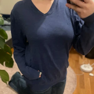Blå tröja från Berkeley - Säljer en stilren blå tröja från Berkeley i storlek L. Tröjan har en v-ringad hals och långa ärmar, perfekt för en avslappnad look. Passar bra till jeans eller chinos.