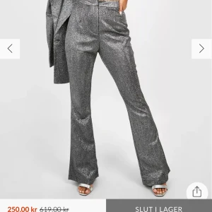 Glittriga byxor från Boohoo - Snygga glittriga byxor från Boohoo i en silverfärg. Byxorna har en hög midja och en bootcut-stil. Perfekta för nyårsfesten! Helt oanvända då de var lite stora för mig i midjan. 