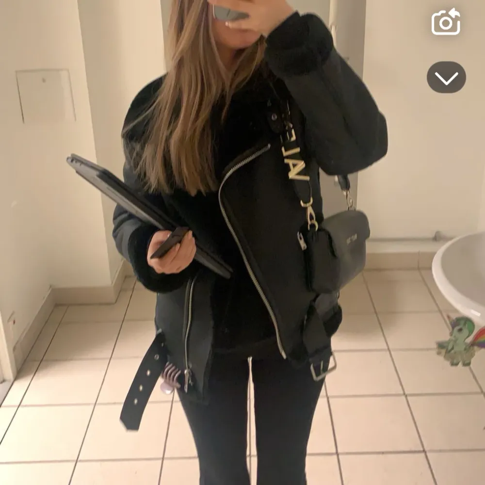 Snygg svart jacka med dragkedja och bälte. . Takit.