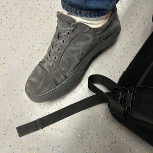 Grå loubs i mocka med röd sula - Snygga grå loubs med en unik röd sula. Skorna har snörning och en stilren design. storlek 42 endast dustbag medföljer.