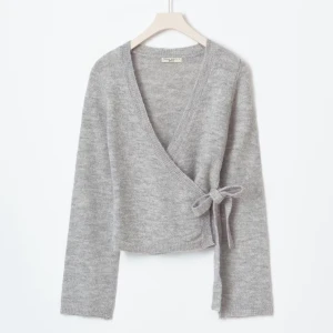 Knitted wrap cardigan  - As snygg stickad cardigan med knytning i midjan, helt oanvänd och lappen sitter kvar! 