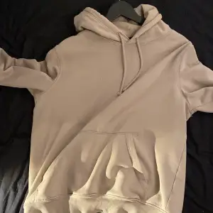 Säljer en beige hoodie från H&M i relaxed fit. Den har en klassisk design med en stor ficka framtill och justerbar huva med dragsko. Perfekt för en avslappnad stil. Ställ fler frågor via dm!