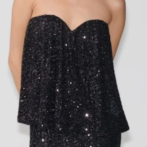 Svart glittrig axelbandslös topp - Snygg svart axelbandslös topp med glittrande paljetter. Slutsåld från gina! I storlek S. Nypris: 399kr säljer för 300