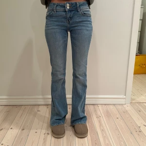 Bootcut jeans från H&M - Snygga lågmidjade bootcut jeans från H&M med mönster på back fickorna.