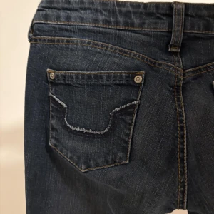 Mörkblå jeans med fickdetaljer - Lågmidjade blå jeans i storlek xs/s!