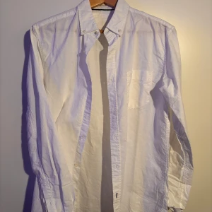 Vit skjorta från Lager 157 - Klassisk vit skjorta från Lager 157 i storlek S. Skjortan har en stilren design med knappar och en bröstficka. Perfekt för en elegant och tidlös look. Knappt använd. Pris kan diskuteras.