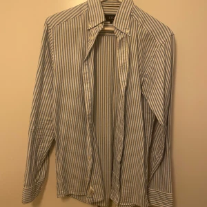 Skjorta från Eton - Snygg randig skjorta från Eton i blått och vitt. Skjortan har en slim passform och långa ärmar, perfekt för en stilren look. Tillverkad i ett bekvämt material med knappar framtill.