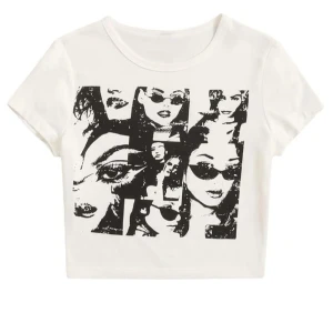 Vit t-shirt med tryck - Trendig vit t-shirt med svart tryck av olika ansikten. Kortärmad och croppad design som ger en cool och avslappnad look. Perfekt för en casual outfit.