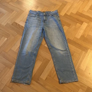 Blå jeansbyxor - Säljer ett par klassiska blå jeansbyxor med normal passform. De har en knapp och dragkedja framtill samt fem fickor. Perfekta för en avslappnad stil.