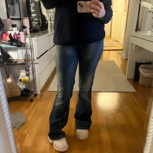 Bootcut jeans - Säljer ett par klassiska blå bootcut jeans med en snygg tvätt. De har en normal passform och är perfekta för en avslappnad stil. Liknar weekday jeansen men de är ifrån asos tror jag. Lite slitna längst ner❤️