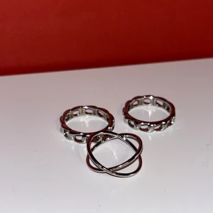 Set med tre silverringar - Snyggt set med tre silverringar. Två av ringarna har ett unikt, genombrutet mönster medan den tredje har en snygg korsad design. 