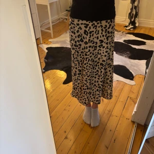Leopardmönstrad kjol från Lindex 🐆⚡️ - Snygg leopardmönstrad kjol från Lindex i en beige och svart färgkombination. Kjolen har en rak passform och är i en längre modell, perfekt för en trendig, glamour look.