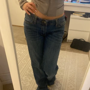 Blå jeans med låg midja från brandy melville  - Snygga blå jeans med låg midja och bootcut-stil. Perfekta för en avslappnad look. De har klassiska fem fickor och knäppning fram. Säljer pga fel storlek. Aldrig använda💕