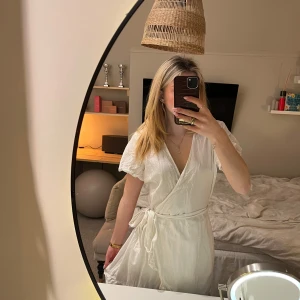 Vit omlottklänning från Nelly - Säljer en söt vit omlottklänning från Nellys gamla kollektion NLY Trend. 💕Klänningen har korta ärmar och ett knytband i midjan för en smickrande passform. Perfekt inför sommaren! Ber om ursäkt för skrynkligheten på bilderna..