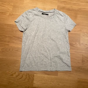 Grå t-shirt från BikBok - Säljer en enkel och stilren grå t-shirt från BikBok i storlek S. T-shirten är kortärmad och tillverkad i mjukt bomullsmaterial. 