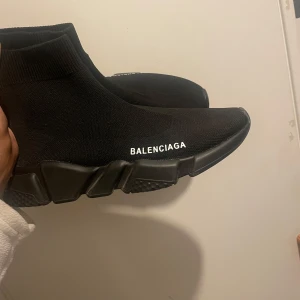 Svarta sneakers  - Snygga svarta sneakers  med en strumpliknande design. Skorna har en tjock sula och är tillverkade i ett stretchigt material för en bekväm passform. Perfekta för en stilren look.  St mellan 38-39