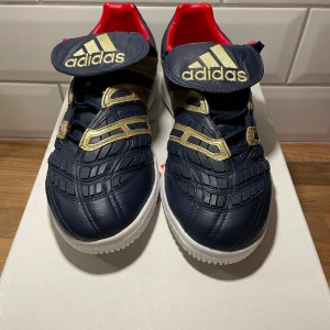 Adidas Accelerator Predator Zidane Special Edition - Snygga Adidas Limited Collection skor med initialerna ZZ inuti då det är Zinedine Zidanes version av Predator 98 i marinblått med guldiga detaljer och röd insida. Perfekta för den som vill sticka ut med stil. Limiterad version. Strl 40, på lådan som medföljer står det 40 2/3. Detta pga fel skick av Adidas. Men efter dialog valde jag att behålla dessa strl minde då övriga strl var slut. Endast testade!! Så helt nya! 