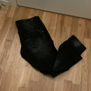 Svarta jeans - Snygga svarta jeans med en klassisk design. Perfekta för en stilren look. De har en rak passform och är tillverkade i ett slitstarkt material.